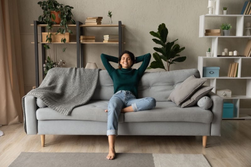 Woman on a couch enjoying her indoor air quality.