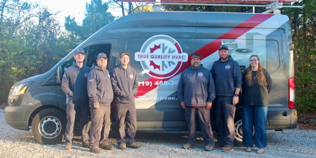 True Quality HVAC team in front of company service van at Crown Point, IN, office.